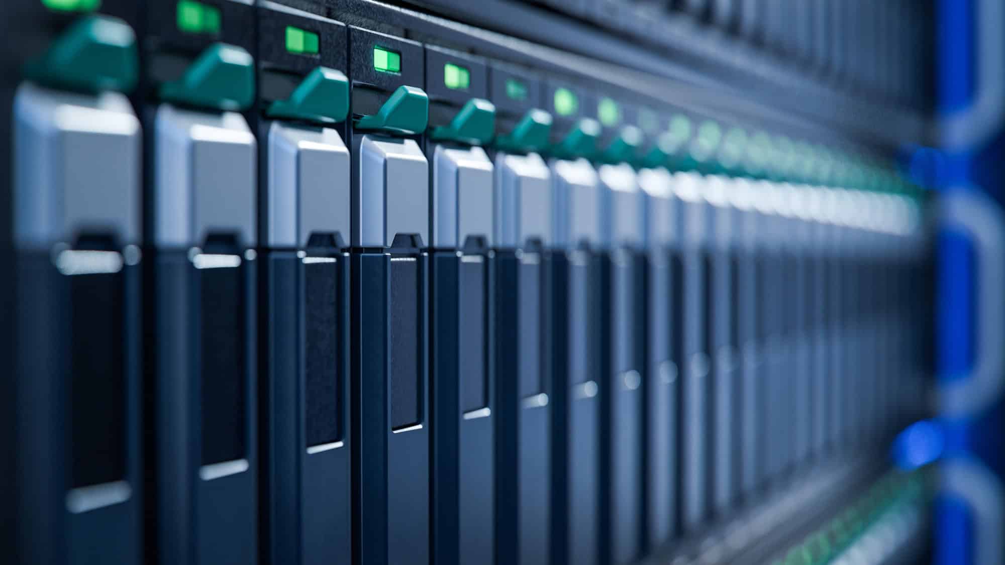 Servidores de computador alinhados em um data center, com luzes verdes e azuis nos equipamentos.