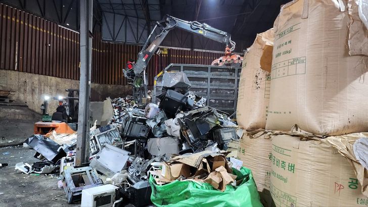 An excavator moves discarded small electronic appliances at a recycling facility in Gimpo, Gyeonggi Province, Monday. Yonhap