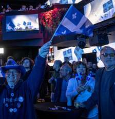 Apoiadores do líder do Parti Quebecois (PQ), Paul St-Pierre Plamondon, acompanham a divulgação dos resultados eleitorais em Montreal, Quebec, no Canadá, em 5 de outubro de 2026. Foto: © ANDREJ IVANOV / AFP / RFI