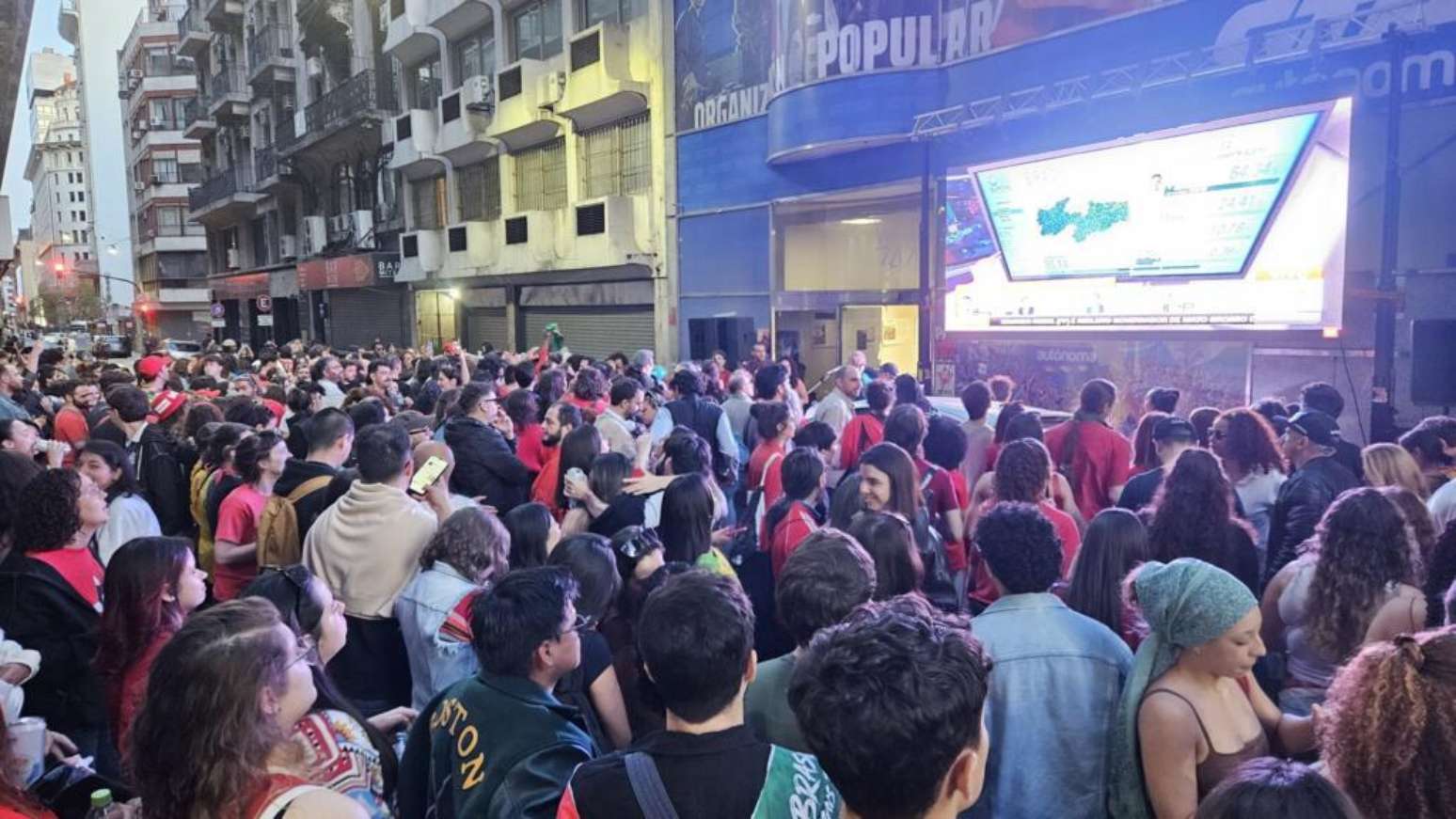 Em Buenos Aires, eleitores do presidente Lula acompanham a apura&ccedil;&atilde;o dos votos diante de um tel&atilde;o.