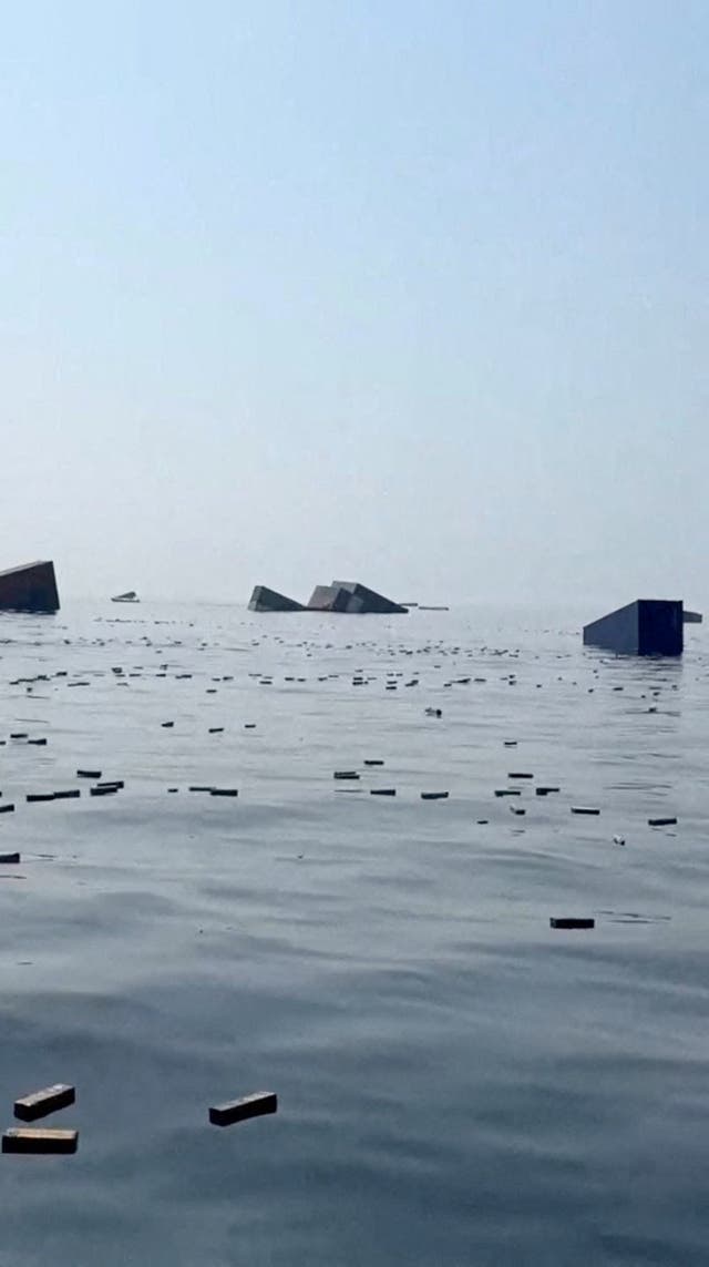 Containers and items float in the water a vessel sank near the Strait of Hormuz off the coast of Oman, in this still image obtained from a social media video, released October 14, 2026.